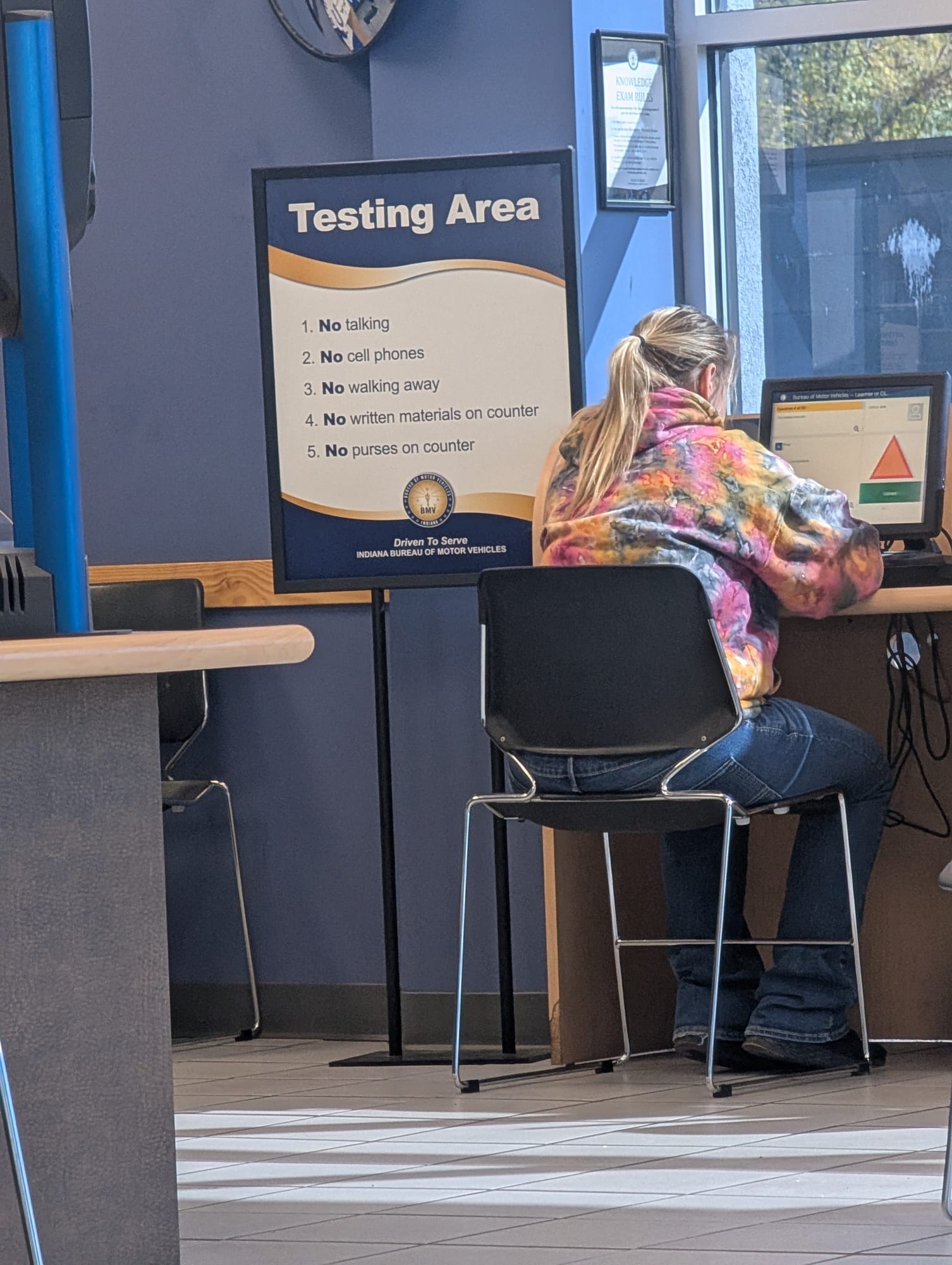 A woman seated at a computer, taking her learner's permit test.