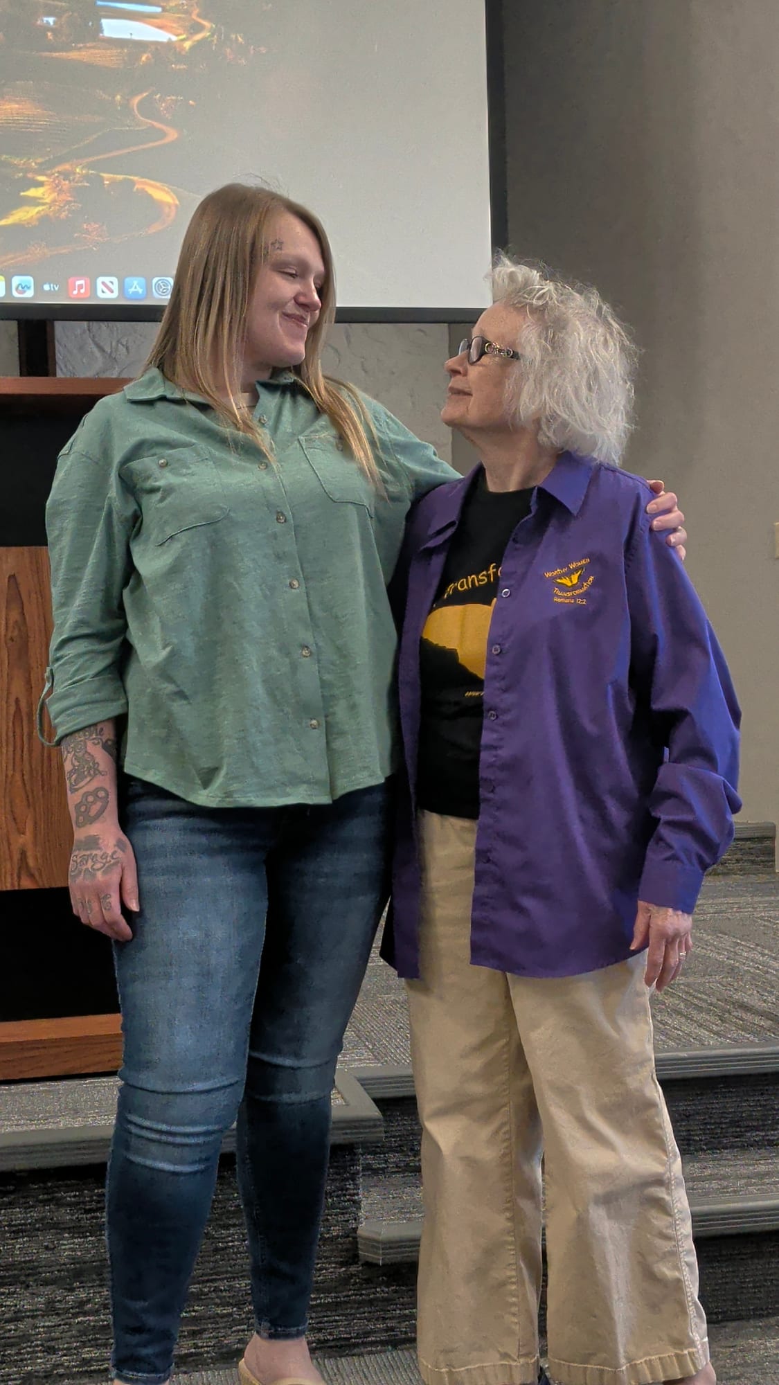 A graduate and the founder smiling at each other during her ceremony.