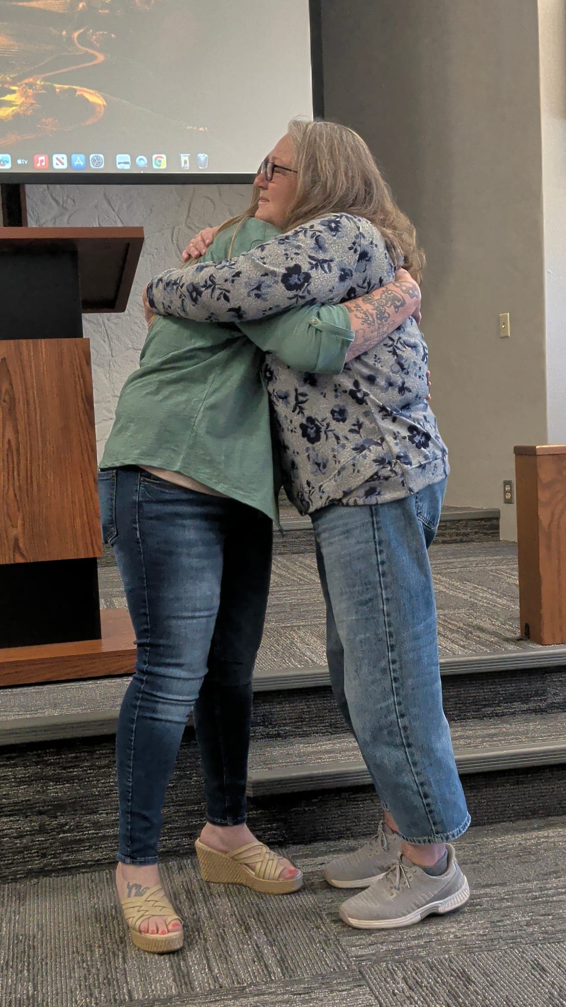 A graduate hugging a loved one at her graduation ceremony.